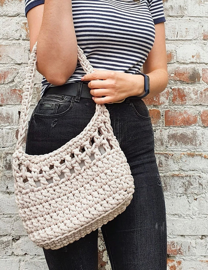 Pale cream crocket bag made of t-shirt yarn on arm of woman