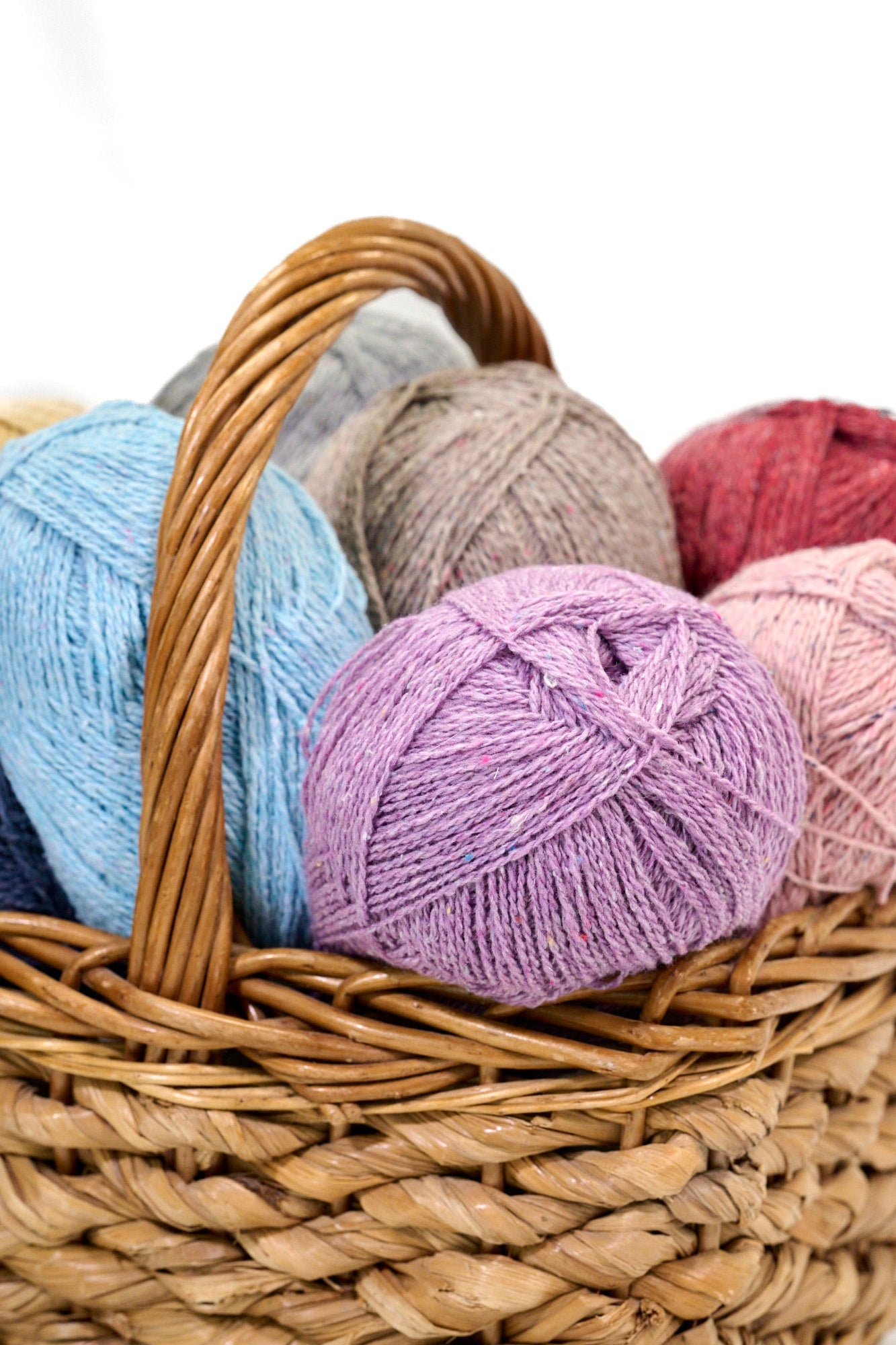 Jolly Good Yarn Recycled DK wool in a range of colours in a wicker basket 