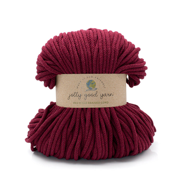 A skein of Jolly Good Yarn recycled braided cord in a deep burgundy red color, wrapped with a natural kraft paper label, on a white background.