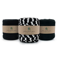 Three skeins of braided yarn from Jolly Good Yarn on a white background: two black, one black and white checkered.