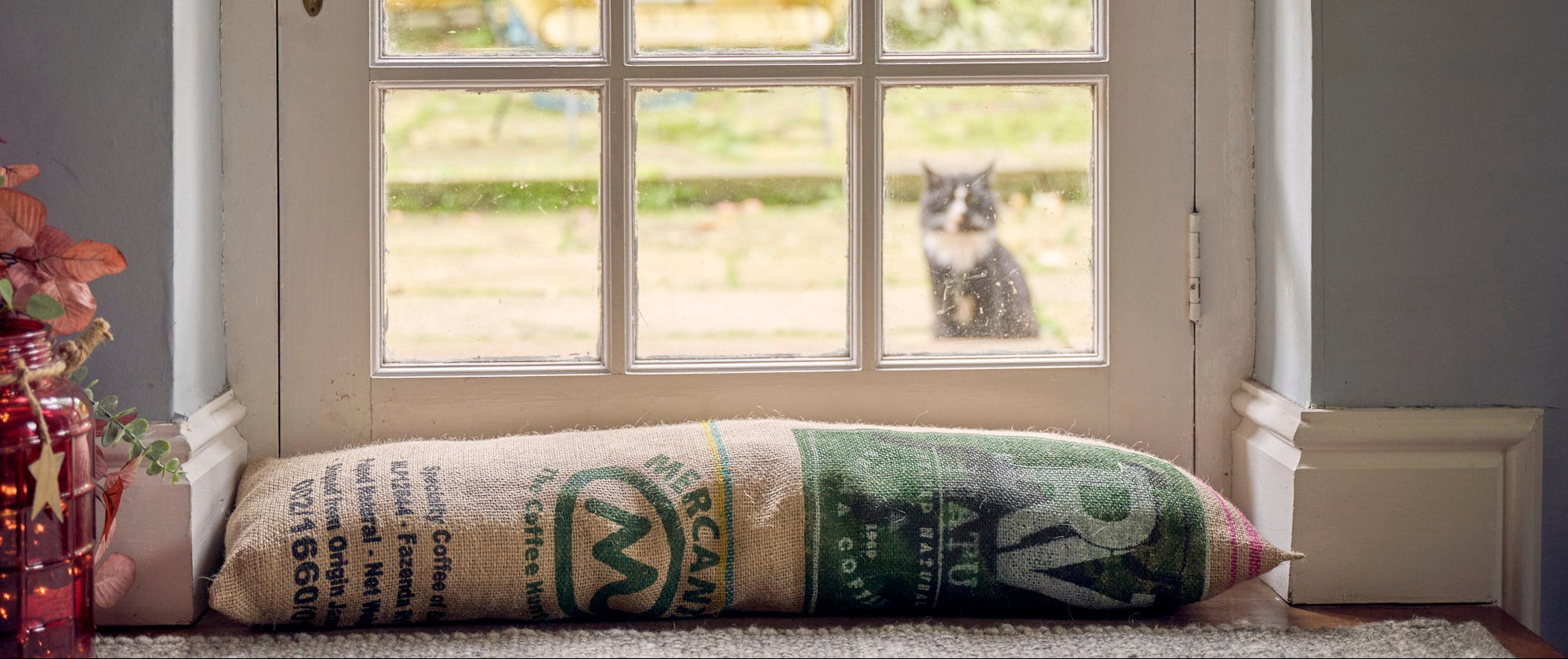 Door draught excluder, with a cat visible outside.