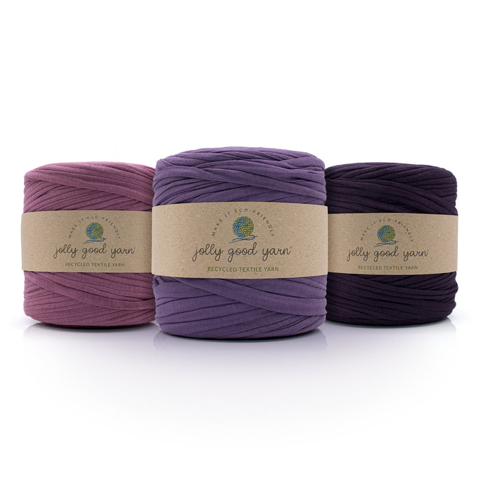 Three balls of different shades of purple yarn with 'jolly good yarn' labels on a white background