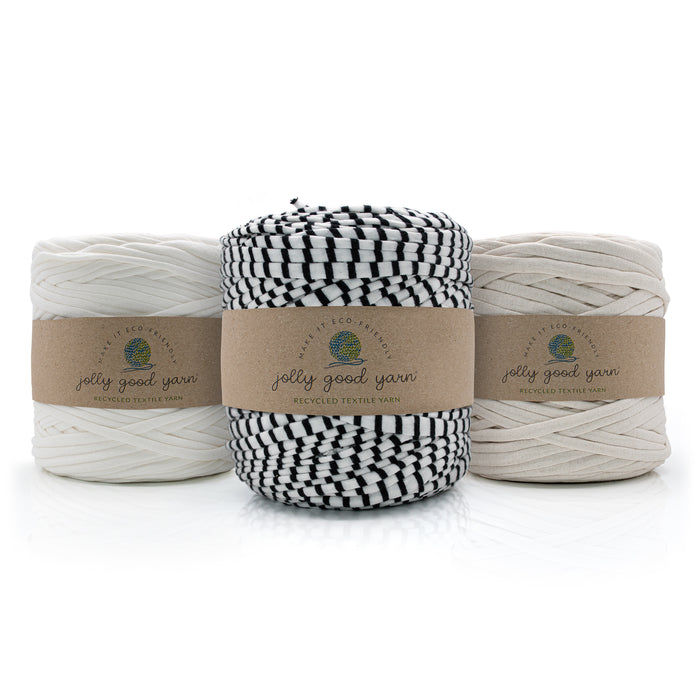Three skeins of twisted cotton yarn from Jelly Good Yarn arranged in a row. The left and right skeins are off-white/cream, and the center skein is black and white striped.